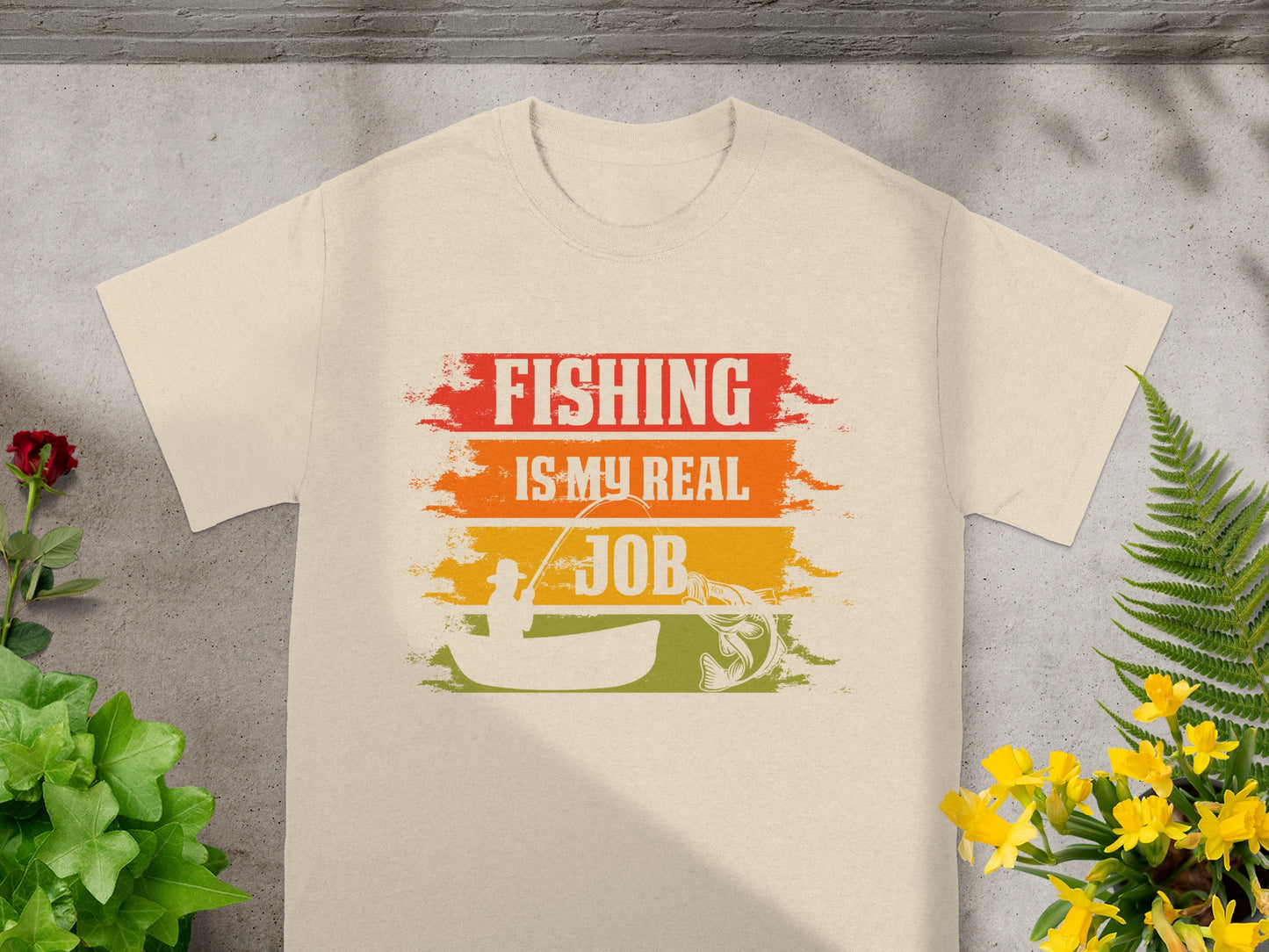 T-shirt with "FISHING IS MY REAL JOB" text, fisherman in boat, and jumping fish graphic.