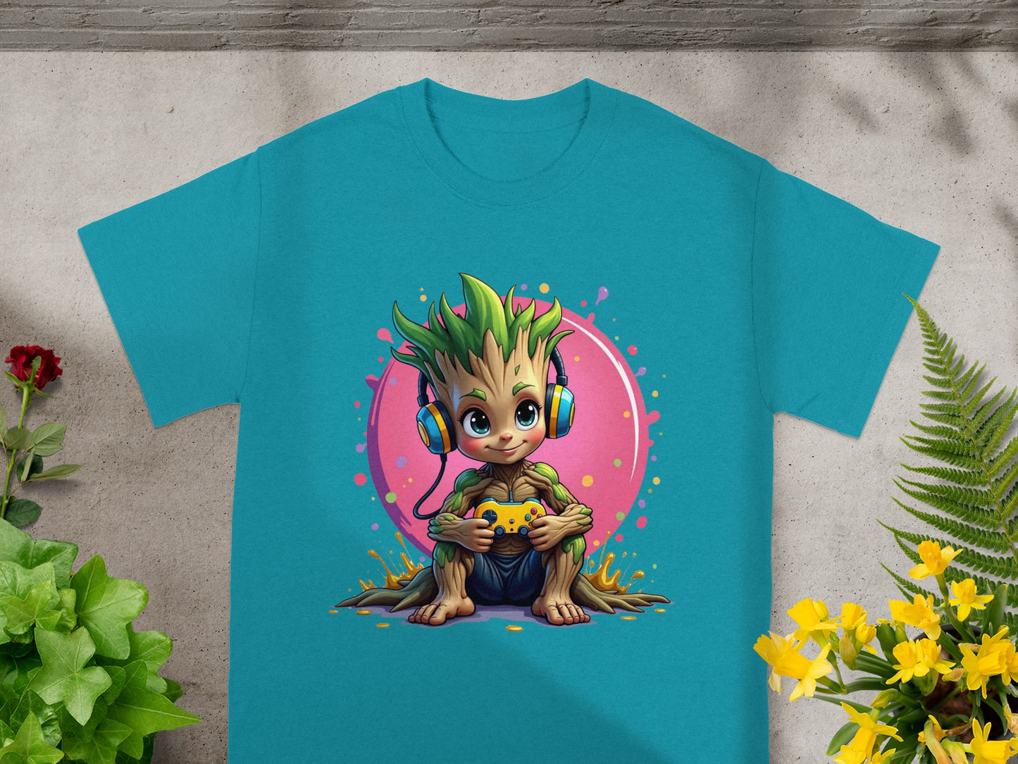 Grogu from Star Wars playing a video game on a teal t-shirt.
