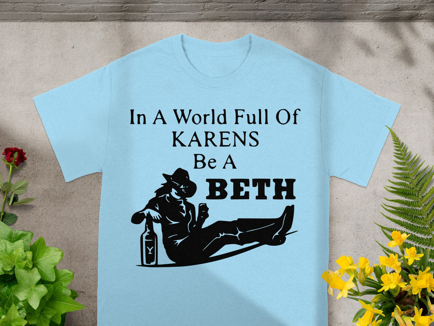 Light blue t-shirt with "In A World Full Of KARENS Be A BETH" text and silhouette.
