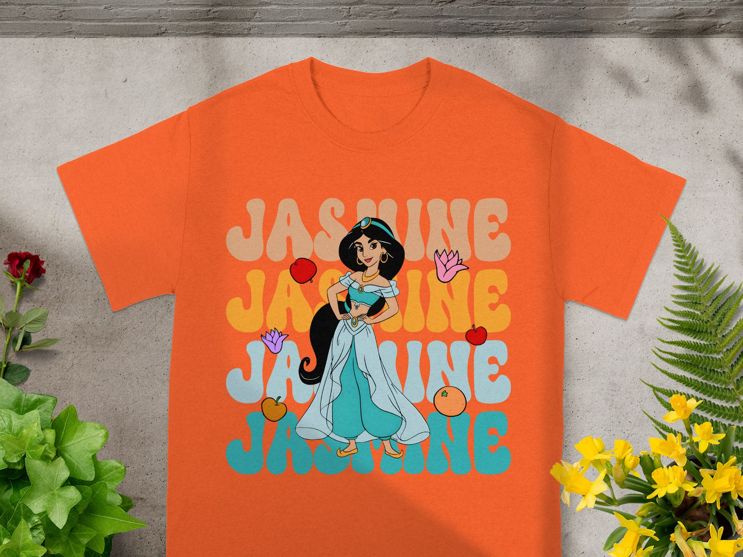 Orange t-shirt with "Jasmine" in retro font and Jasmine cartoon character.