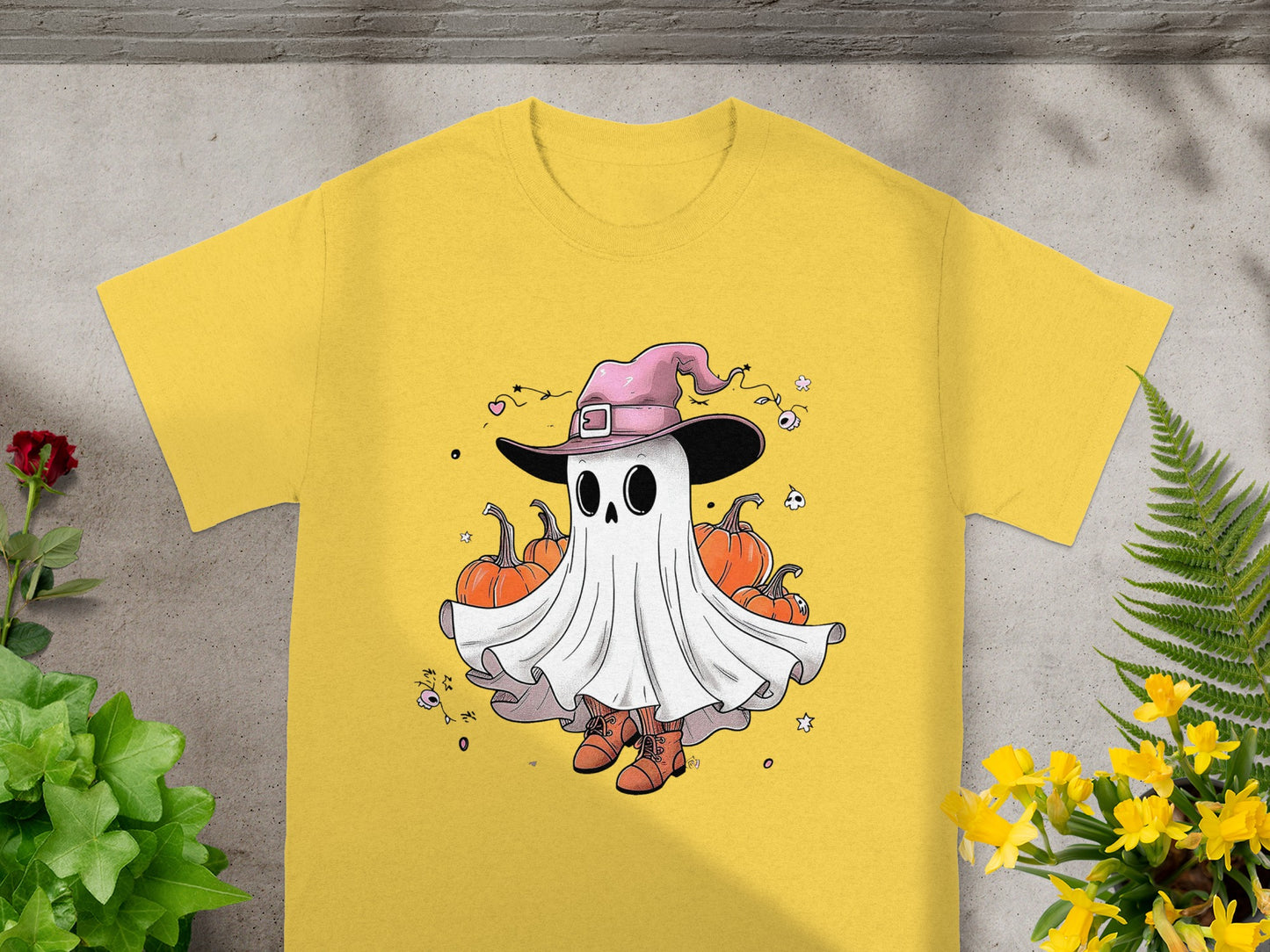 Yellow t-shirt with cartoon ghost wearing witch hat and standing with pumpkins.