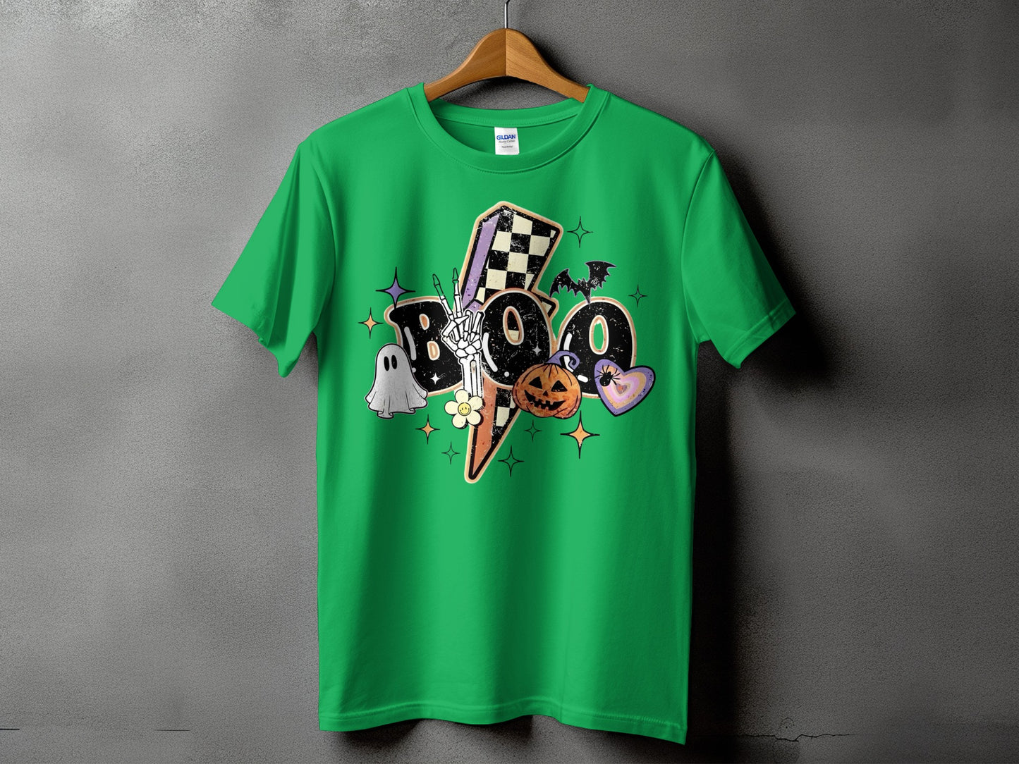 Green t-shirt with Halloween graphic featuring "Boo," skeleton hand, ghost, pumpkin, and lightning bolt.
