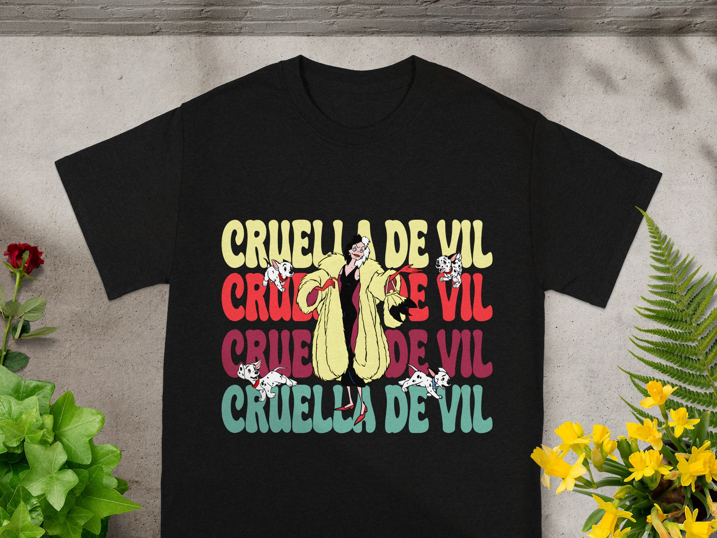 Black t-shirt with "Cruella de Vil" text in distressed colorful font.