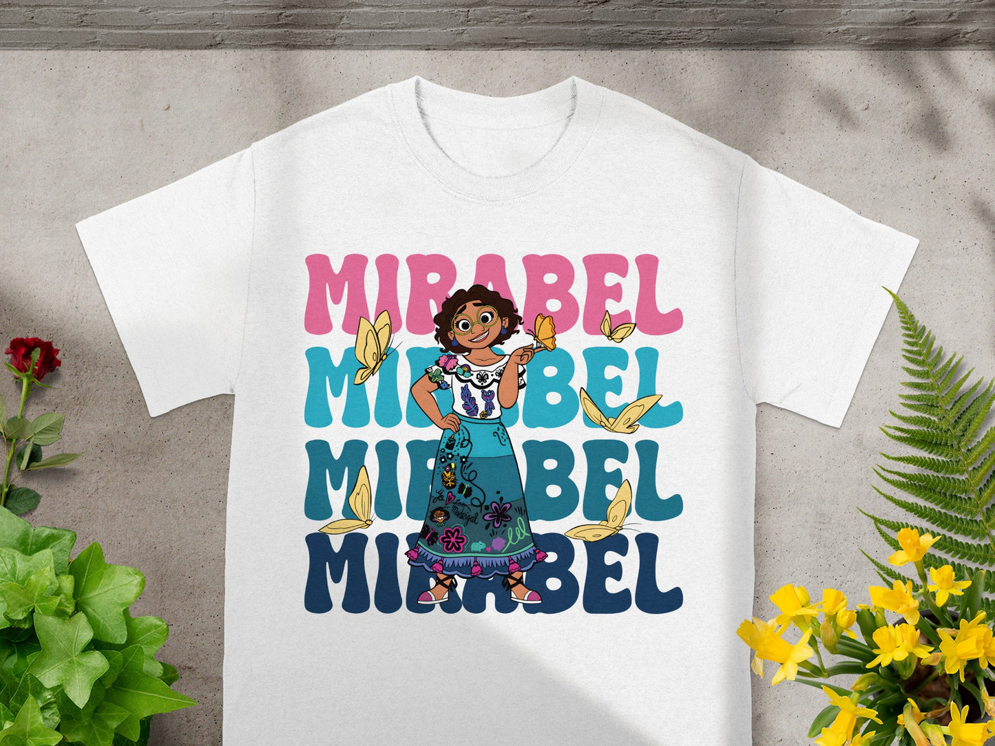 White t-shirt with Mirabel and butterflies graphic and text.