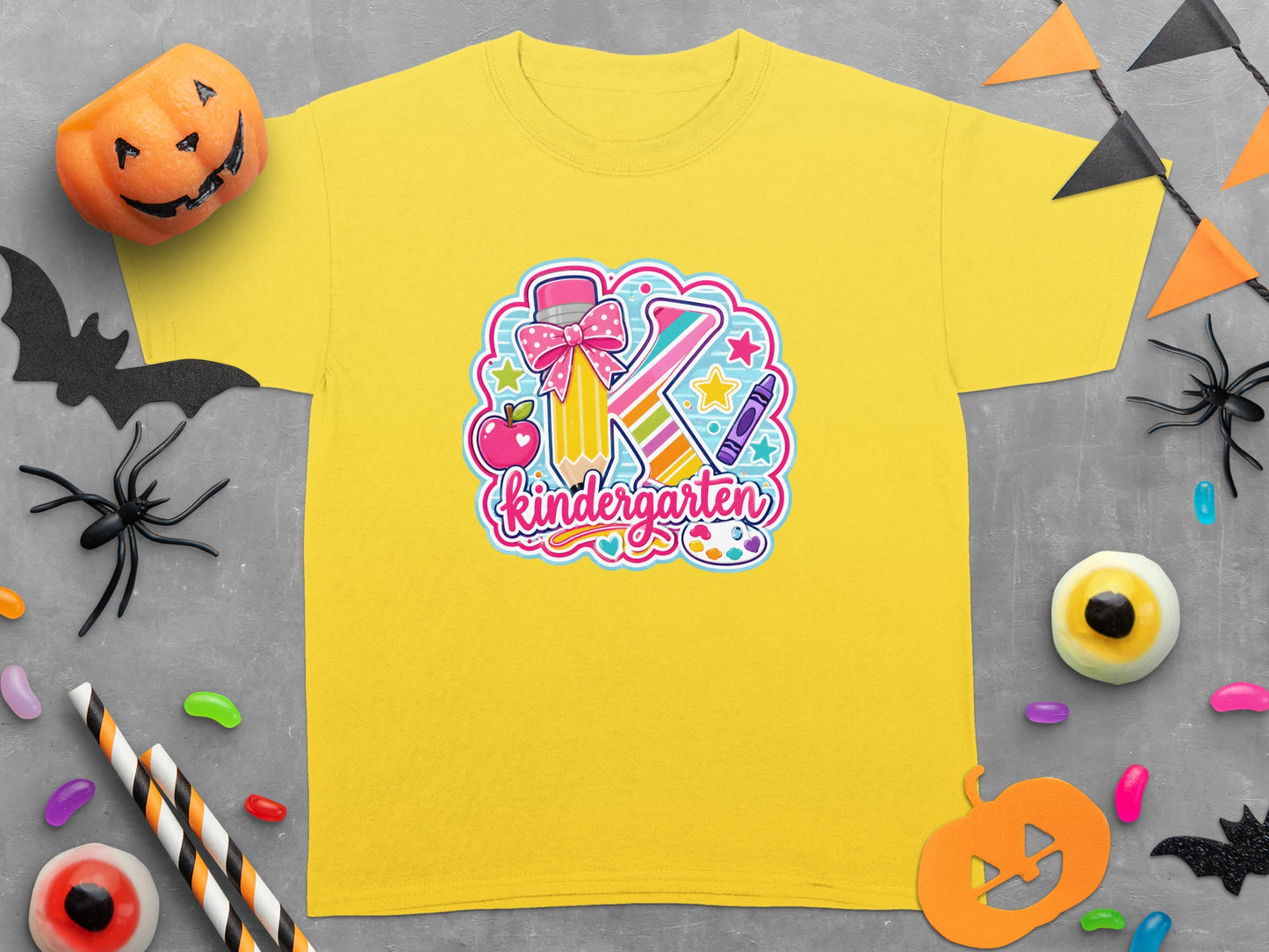 Yellow t-shirt with "Kindergarten" design featuring a large "K", pencil, apple, and crayon.