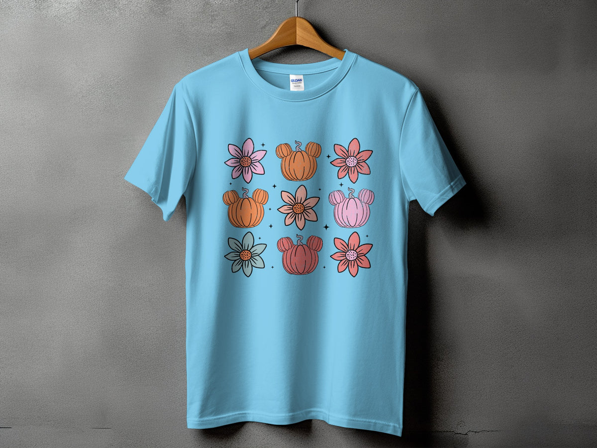 Light blue t-shirt with a grid of cartoon flowers and pumpkins with Mickey Mouse ears.