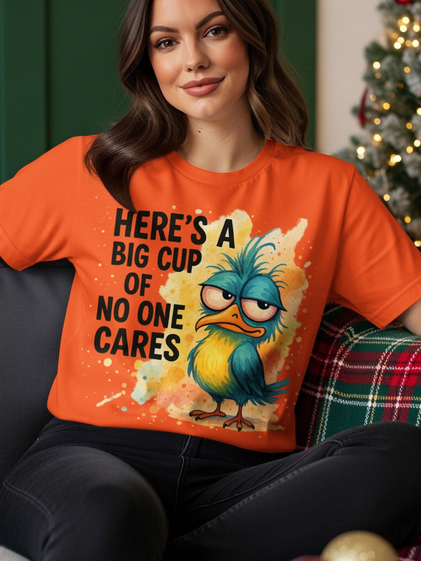 Orange t-shirt with a cartoon bird saying "Here's a big cup of no one cares".