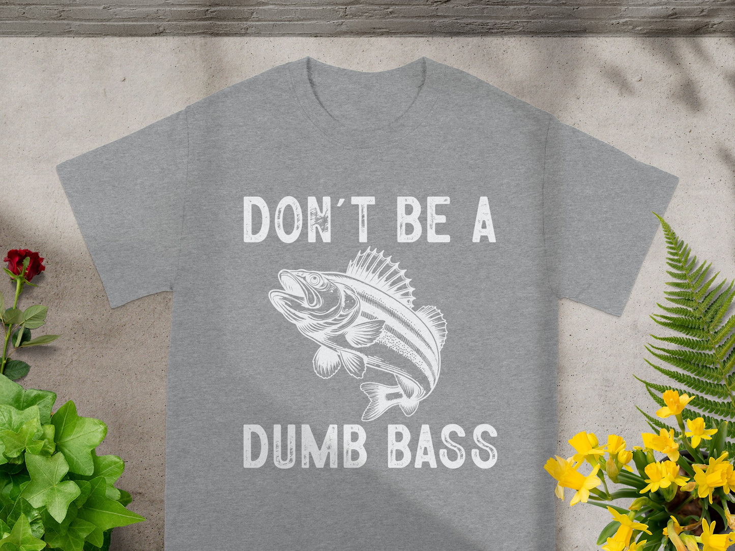 Grey t-shirt with white text "DON'T BE A DUMB BASS" and a drawing of a fish.