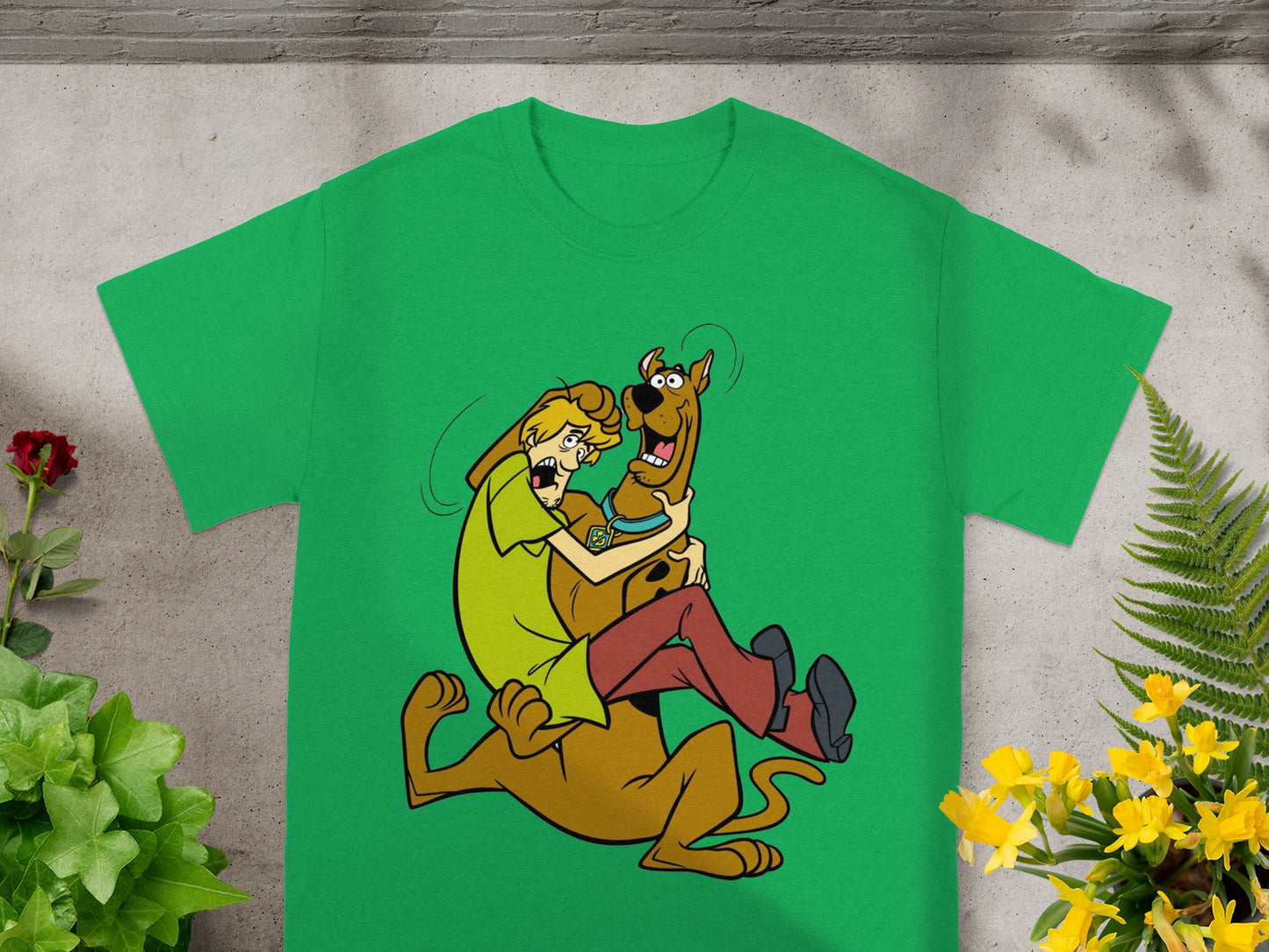 Shaggy hugs Scooby-Doo on a green t-shirt with cartoon animation.