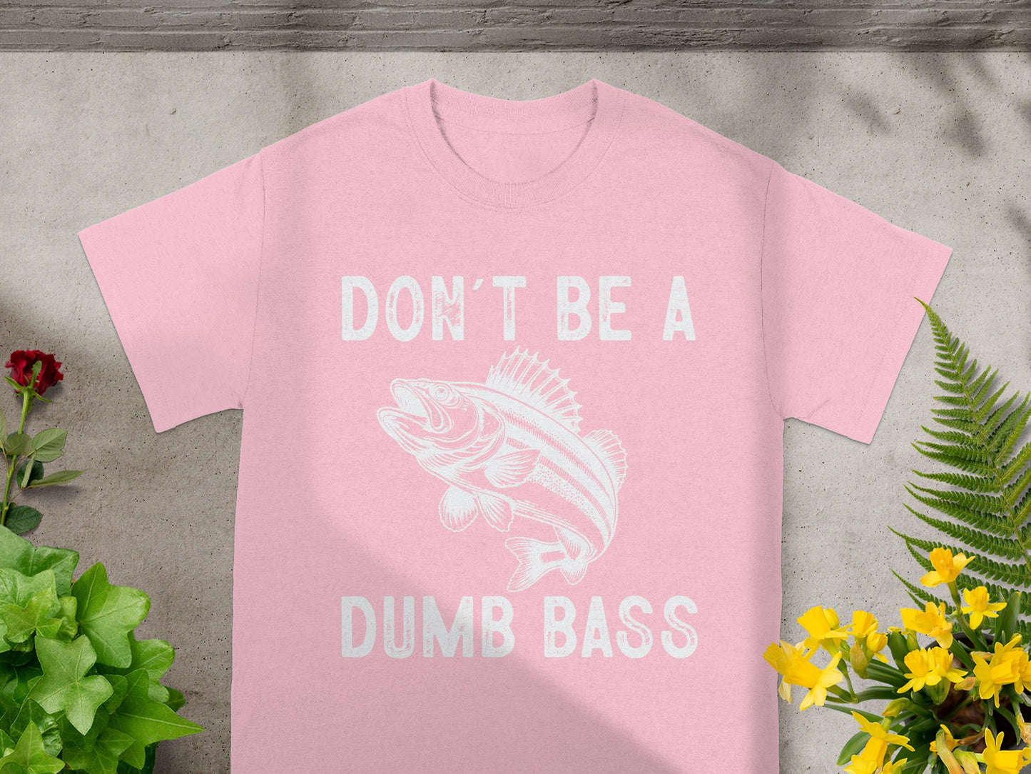 Pink t-shirt with white text "DON'T BE A DUMB BASS" and fish graphic.
