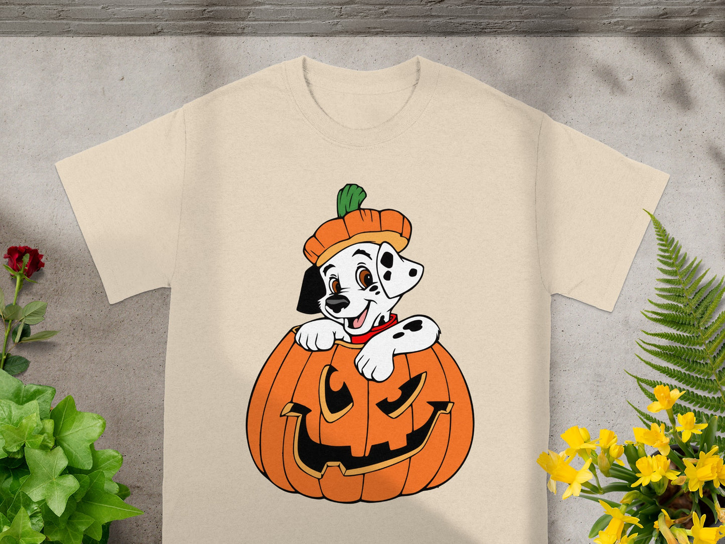 Dalmatian puppy peeking out of a jack-o'-lantern on a cream t-shirt.