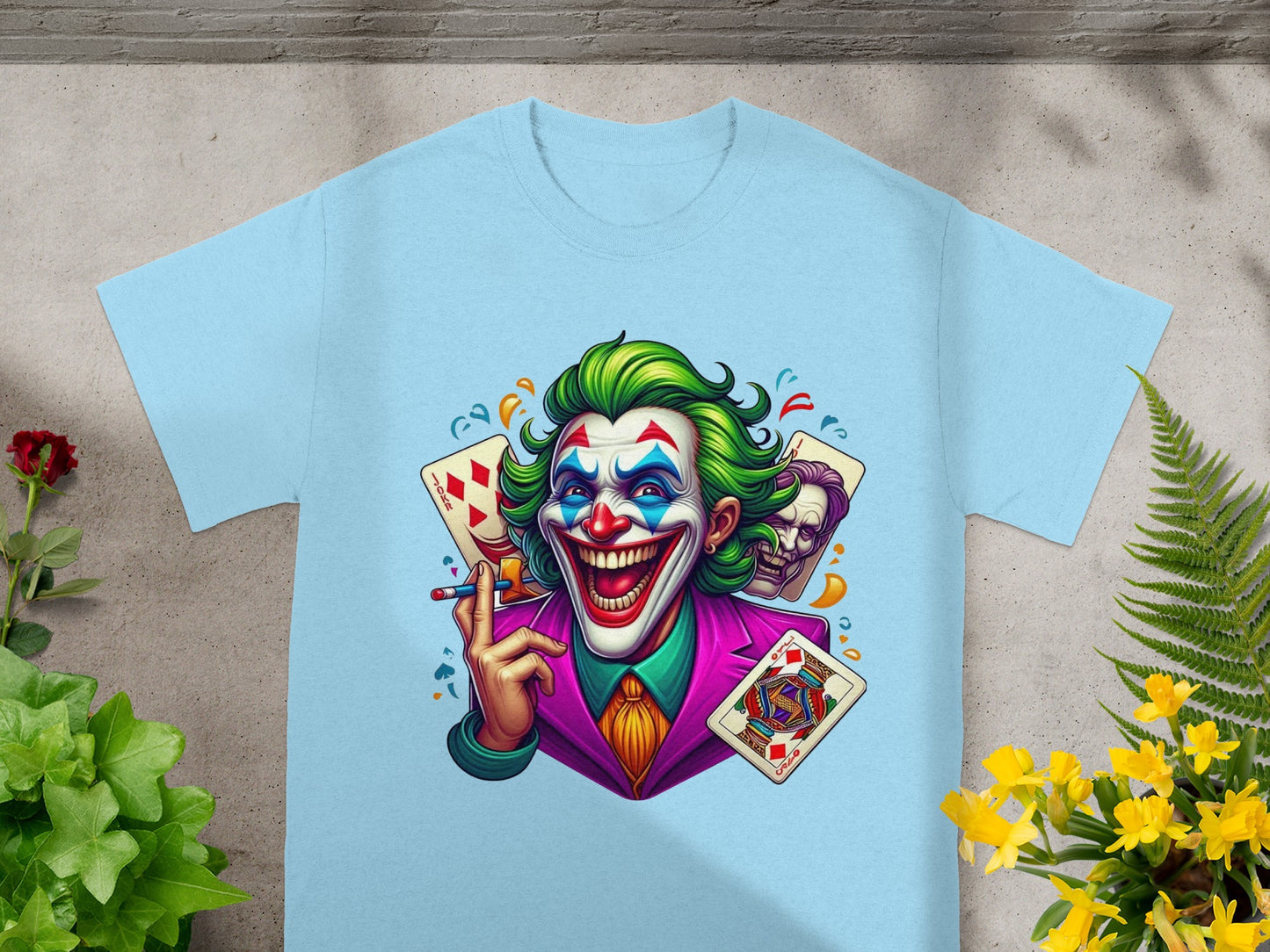 Joker character with playing cards, green hair, and purple suit on light blue t-shirt.