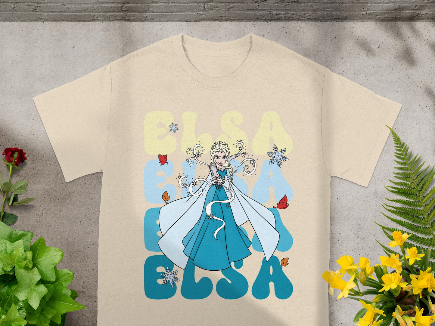 Cream t-shirt with Elsa from Frozen, snowflakes, and yellow text.