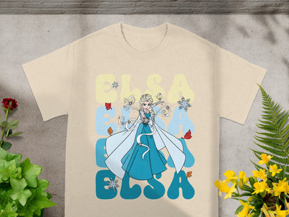Cream t-shirt with Elsa from Frozen, snowflakes, and yellow text.