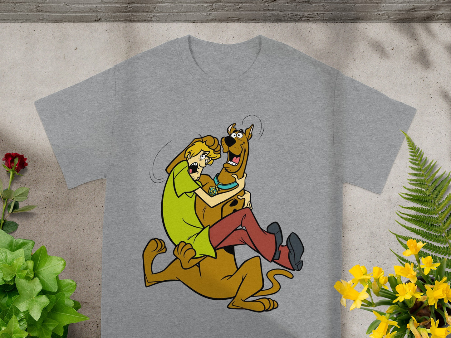 Scooby-Doo and Shaggy embrace in a cartoon graphic on a grey t-shirt.