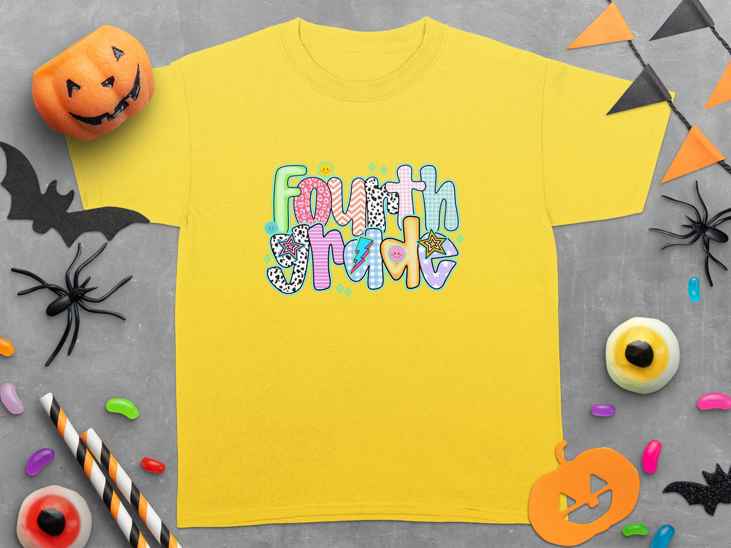 Yellow t-shirt with colorful "Fourth Grade" text and Halloween decorations.