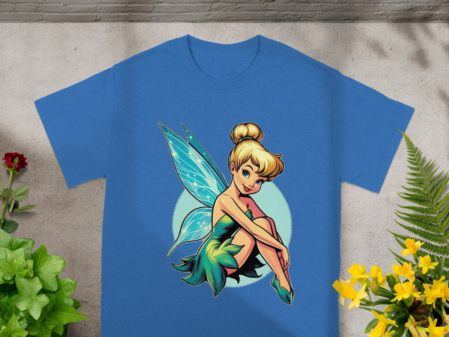Tinkerbell illustration on a blue t-shirt with green accents.