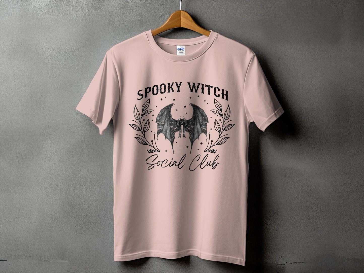 Pink t-shirt with "Spooky Witch Social Club" text and bat wings graphic.