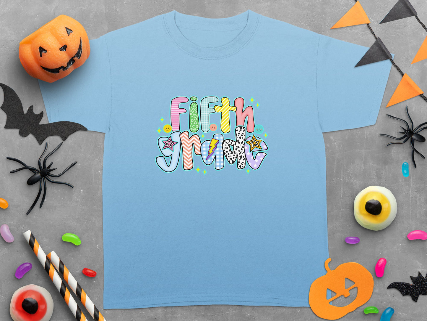 Light blue t-shirt with colorful "Fifth Grade" text and Halloween decorations.