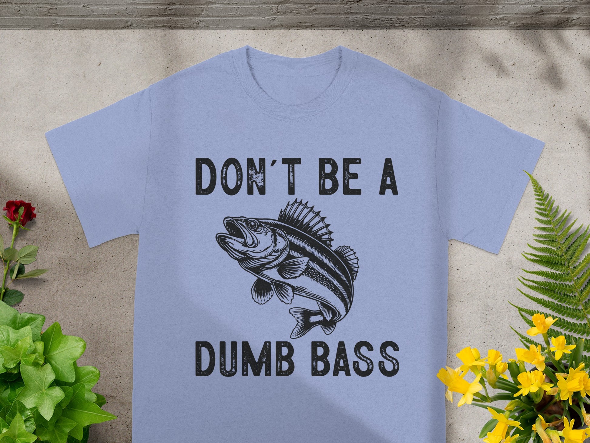 Light blue t-shirt with black text "DON'T BE A DUMB BASS" and a fish graphic.