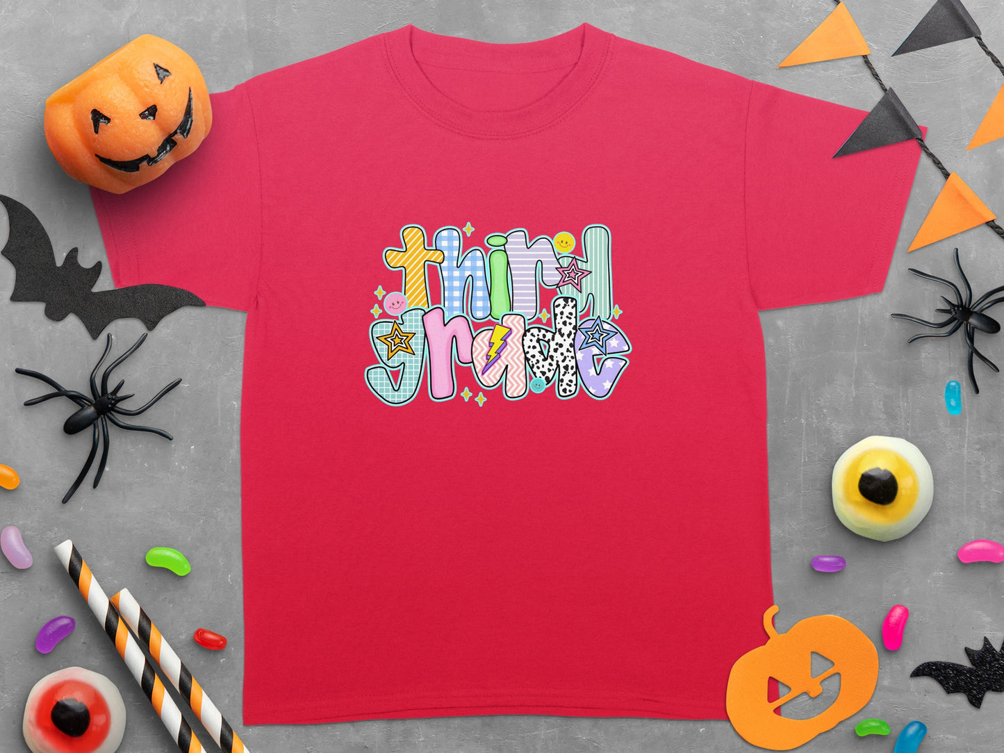 Crimson t-shirt with "Third Grade" in colorful, patterned lettering and Halloween decorations.