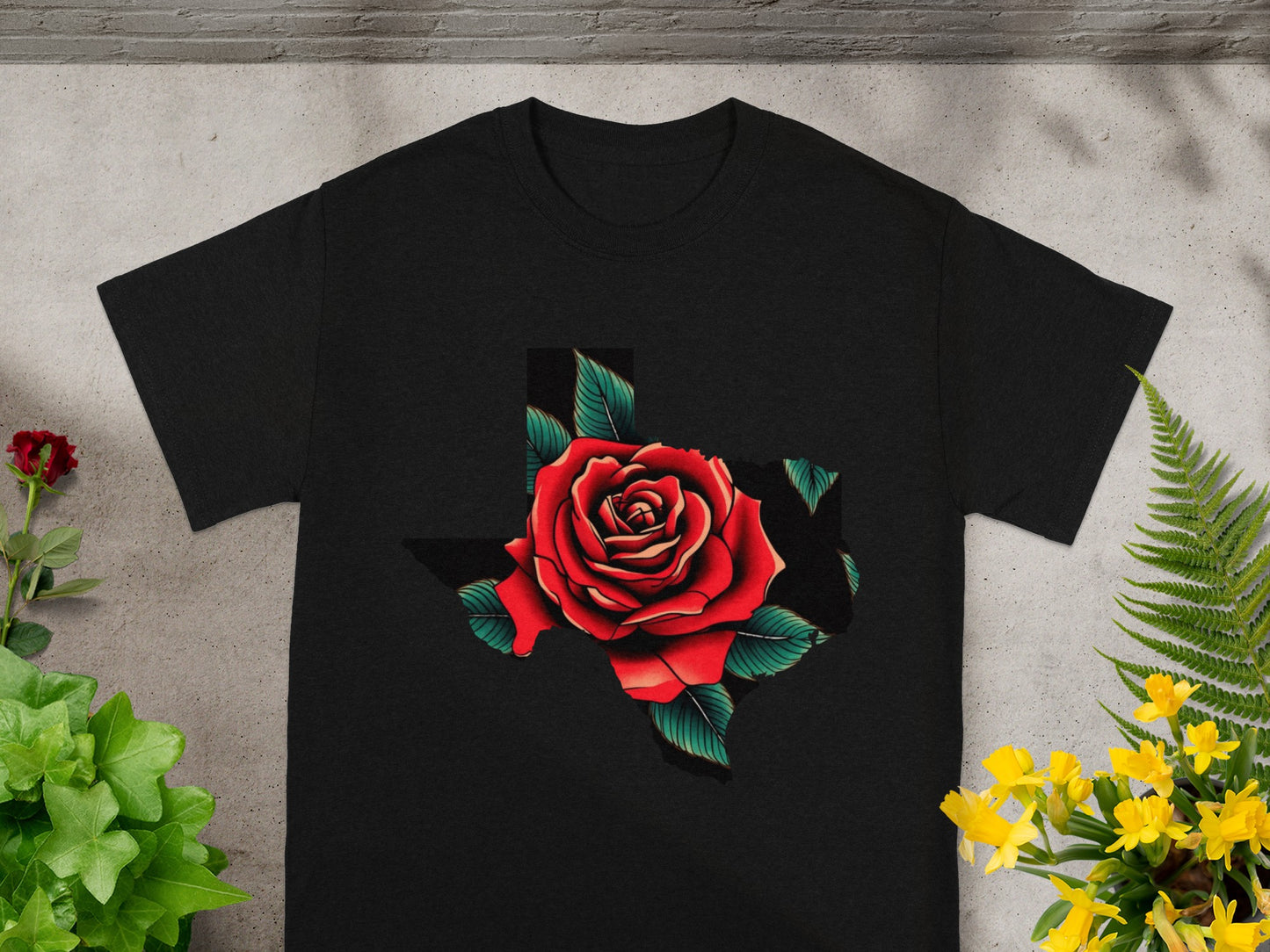 Black t-shirt with a red rose graphic inside the outline of the state of Texas.