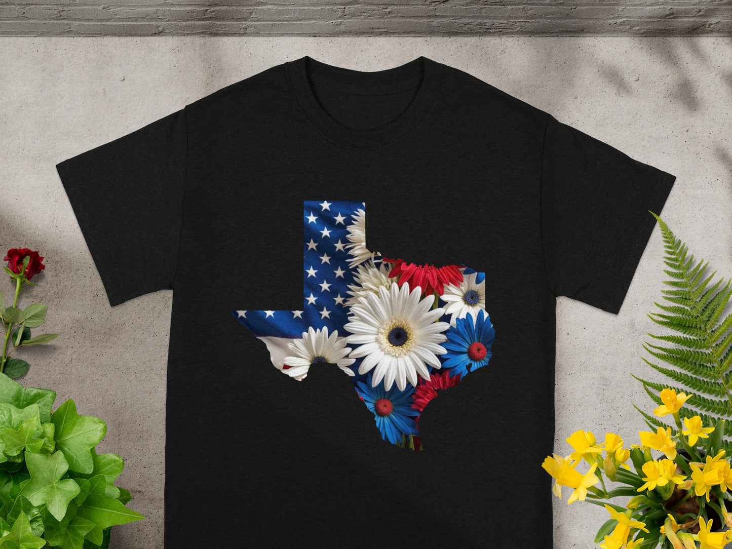 Black t-shirt with Texas outline filled with American flag and patriotic flowers.