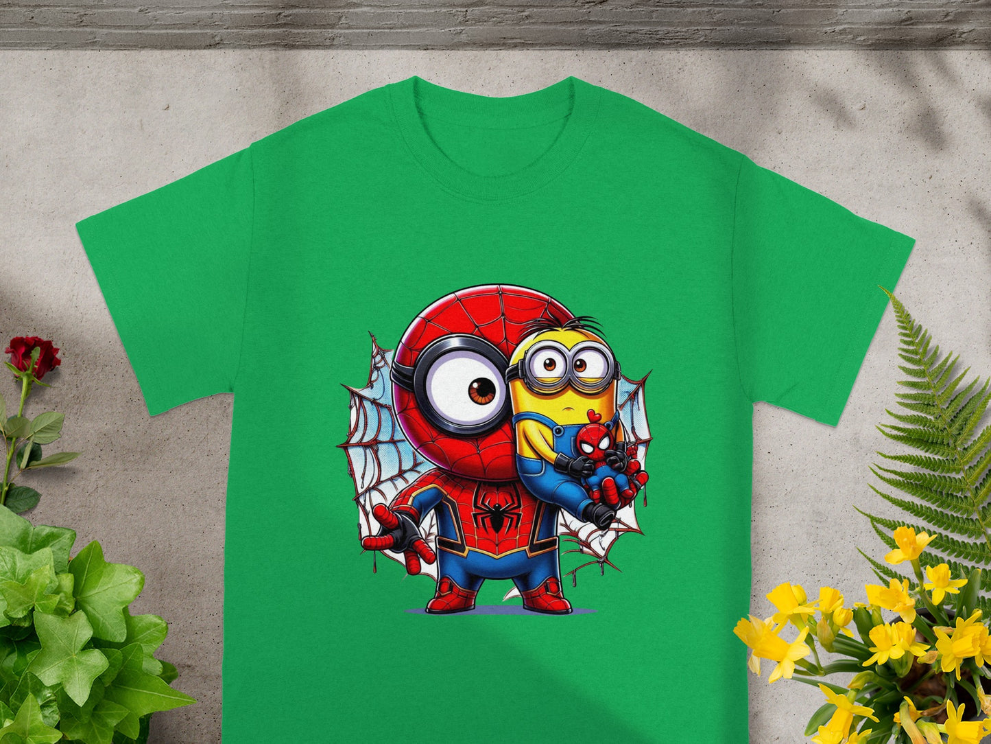 Minion dressed as Spider-Man holds a Spider-Man toy on a green t-shirt.