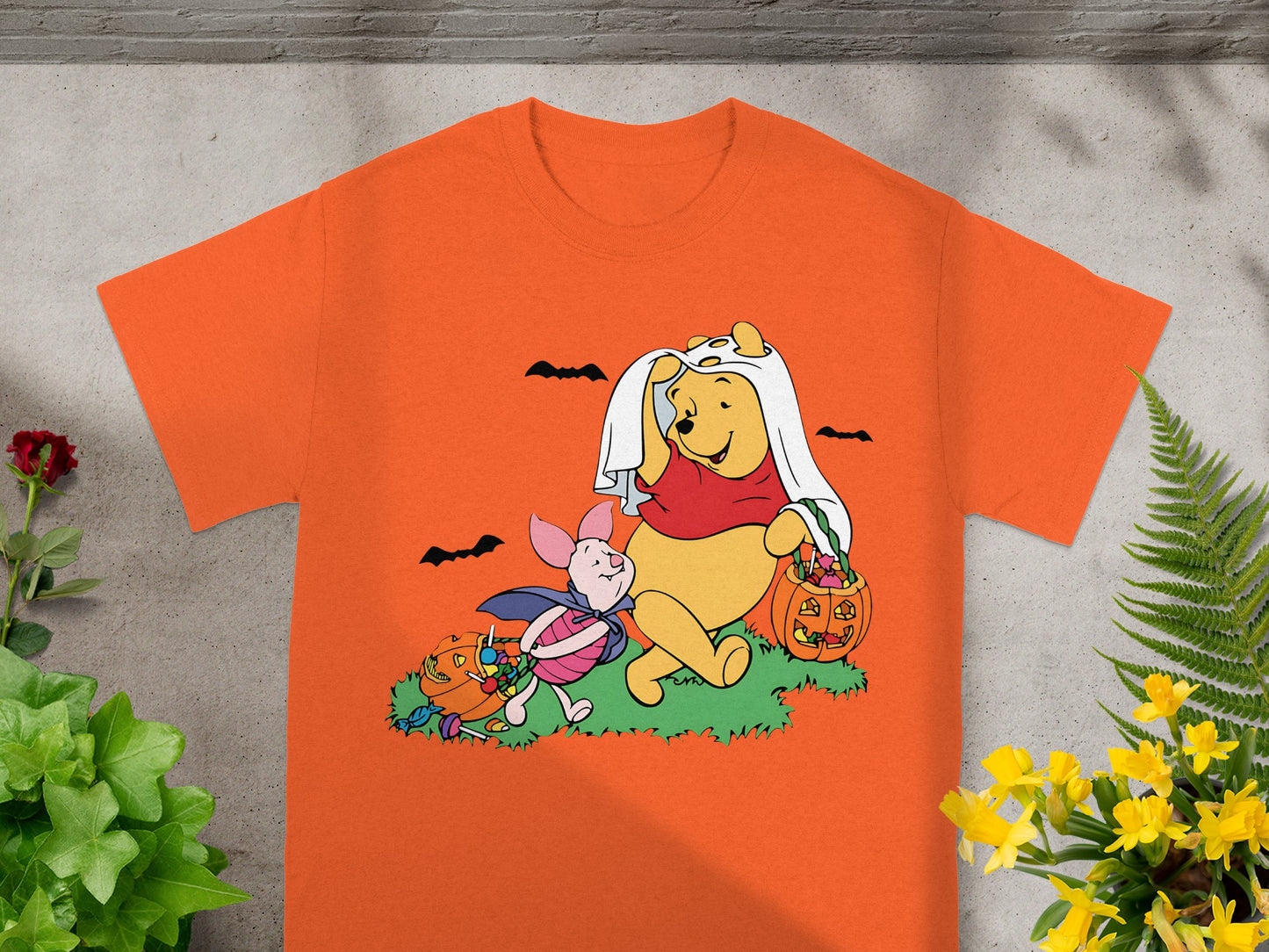 Winnie the Pooh and Piglet in Halloween costumes with pumpkins and candy.