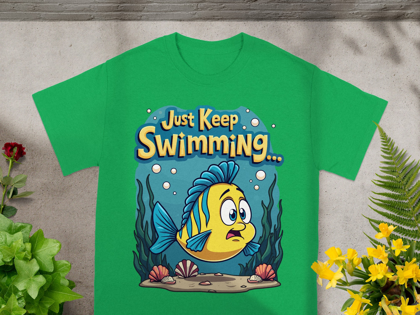 Green t-shirt with cartoon fish and text "Just Keep Swimming...".