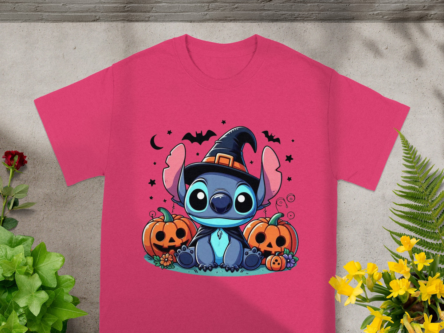 Stitch in a witch hat sits with pumpkins and bats on a pink t-shirt.