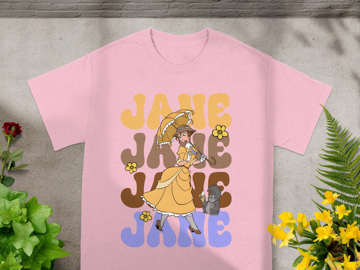 Pink t-shirt with retro "Jane" graphic featuring a woman with umbrella and monkey.