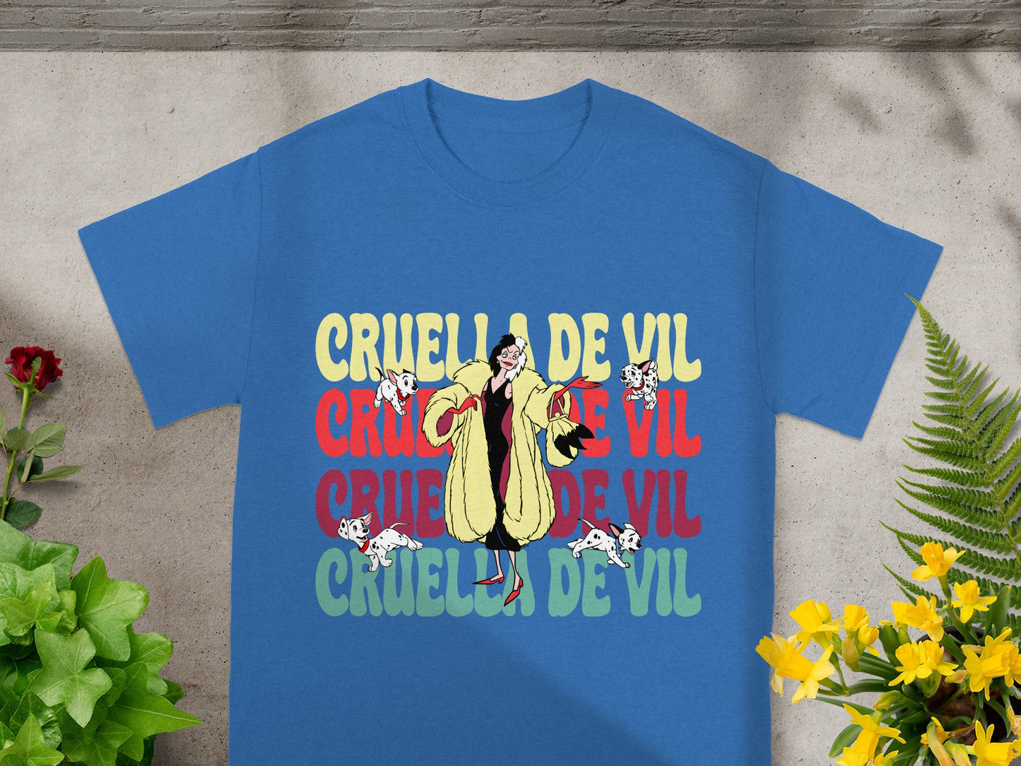 Blue t-shirt with Cruella de Vil and Dalmatians graphic.