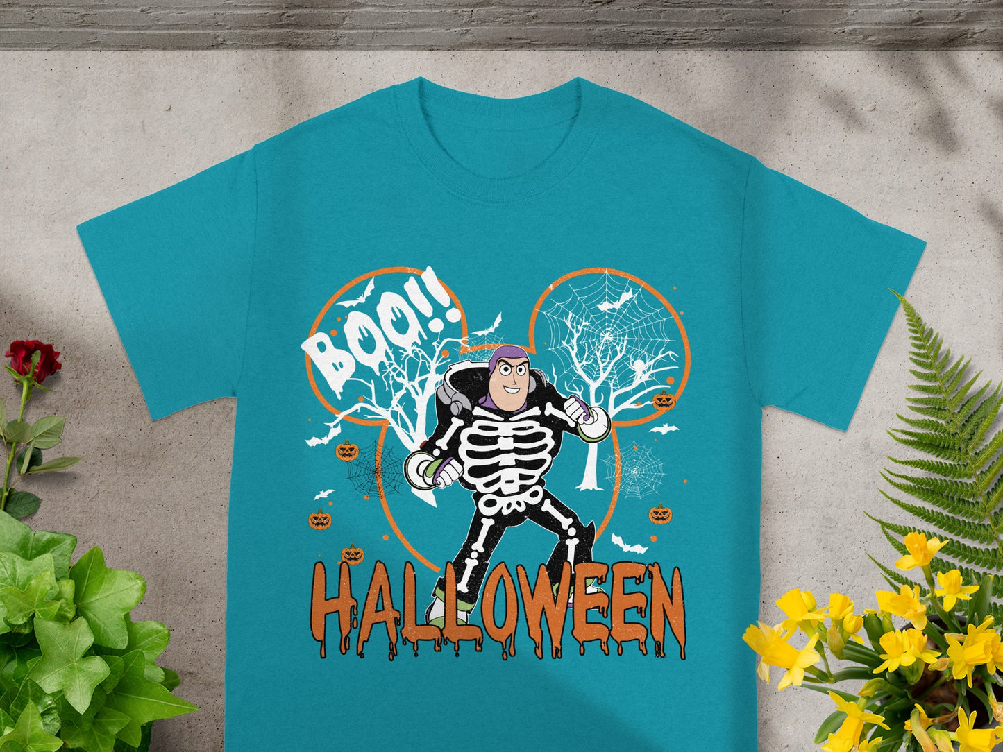 Buzz Lightyear skeleton costume graphic on a teal Halloween t-shirt with "Boo!!" and "Halloween" text.