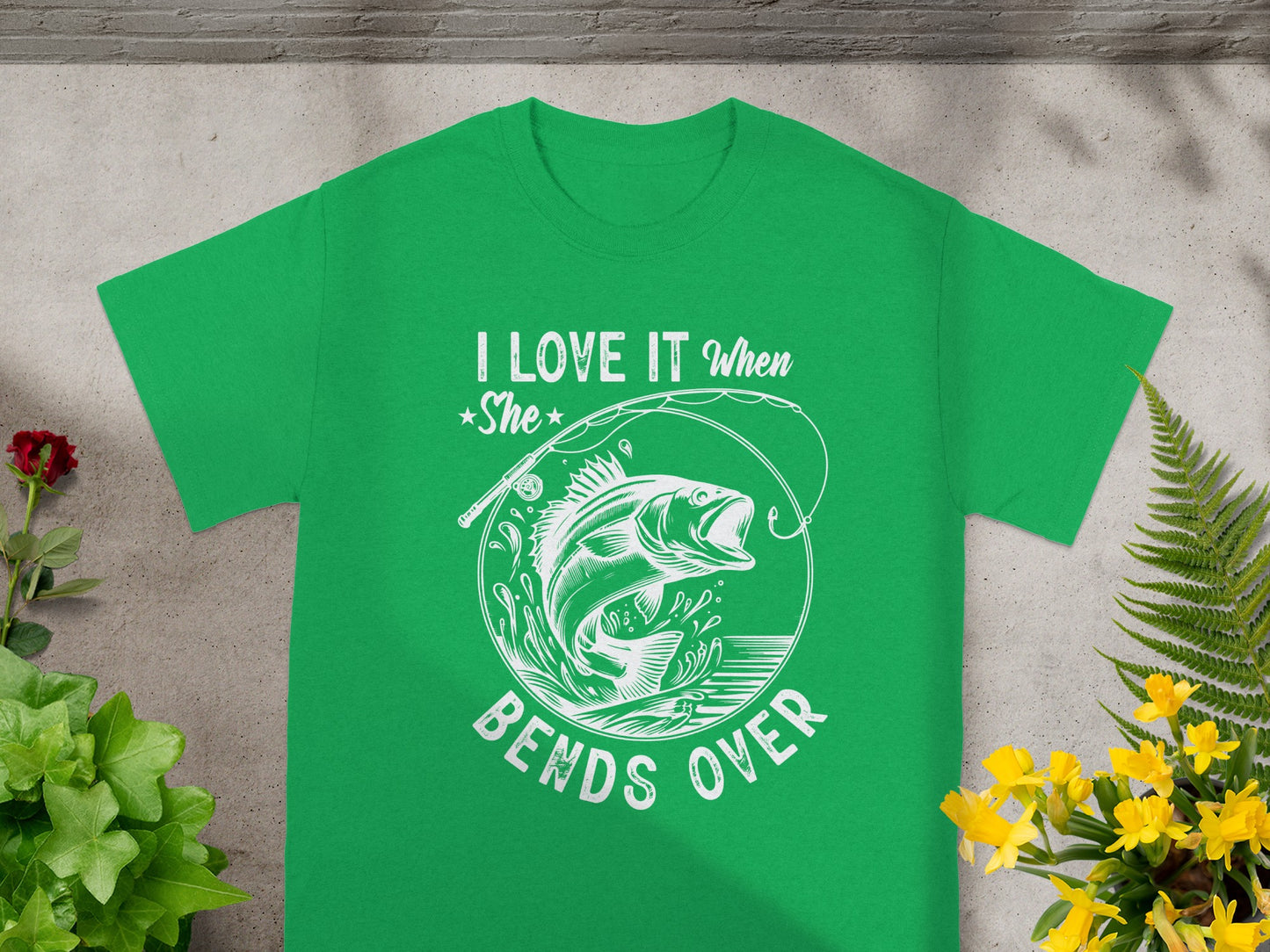 Green t-shirt with white text "I LOVE IT When She BENDS OVER" and a fish graphic.