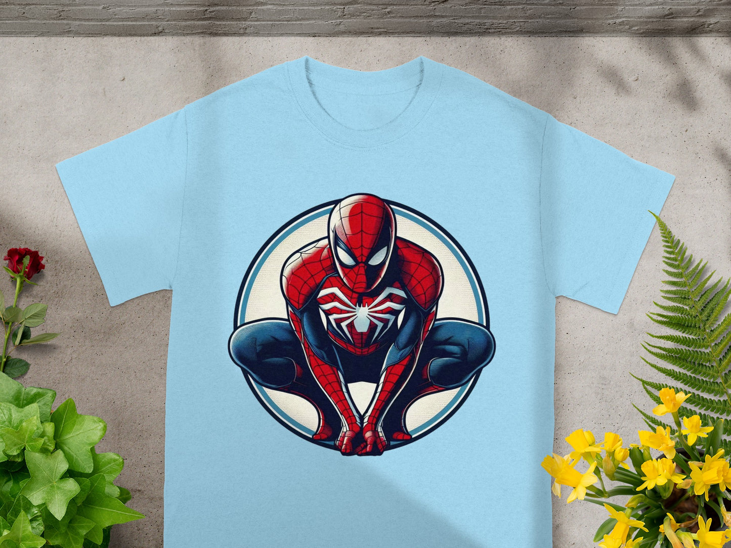 Spider-Man crouching in a blue circular frame on a light blue t-shirt.