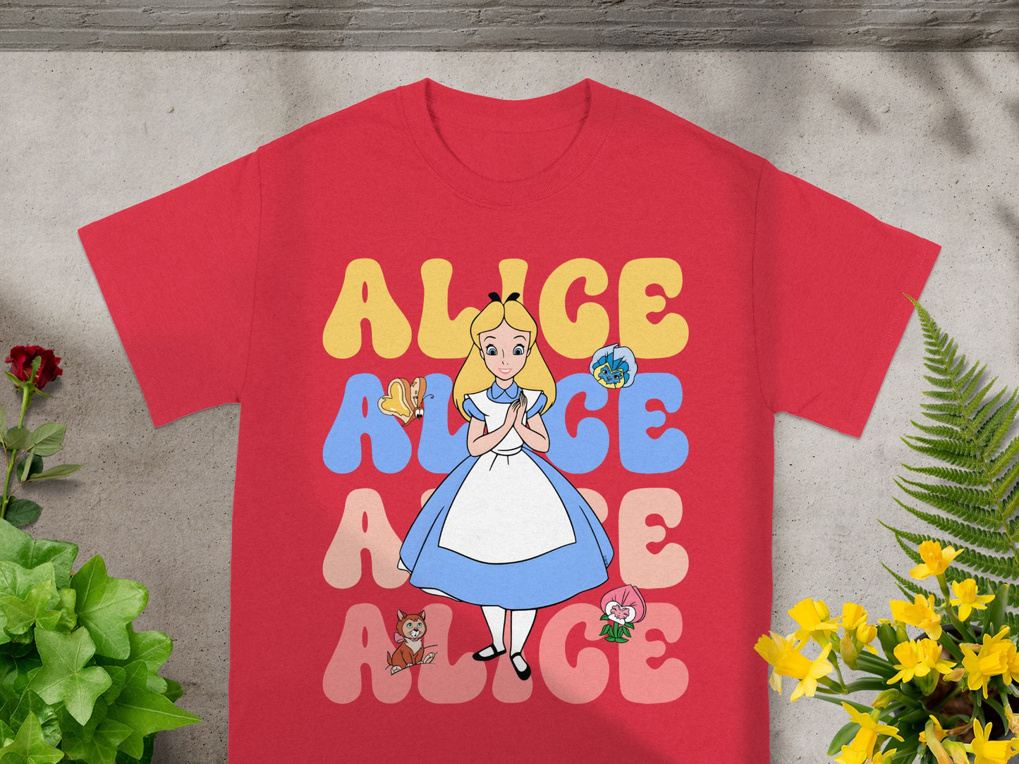 Red t-shirt with Alice in Wonderland characters and text.