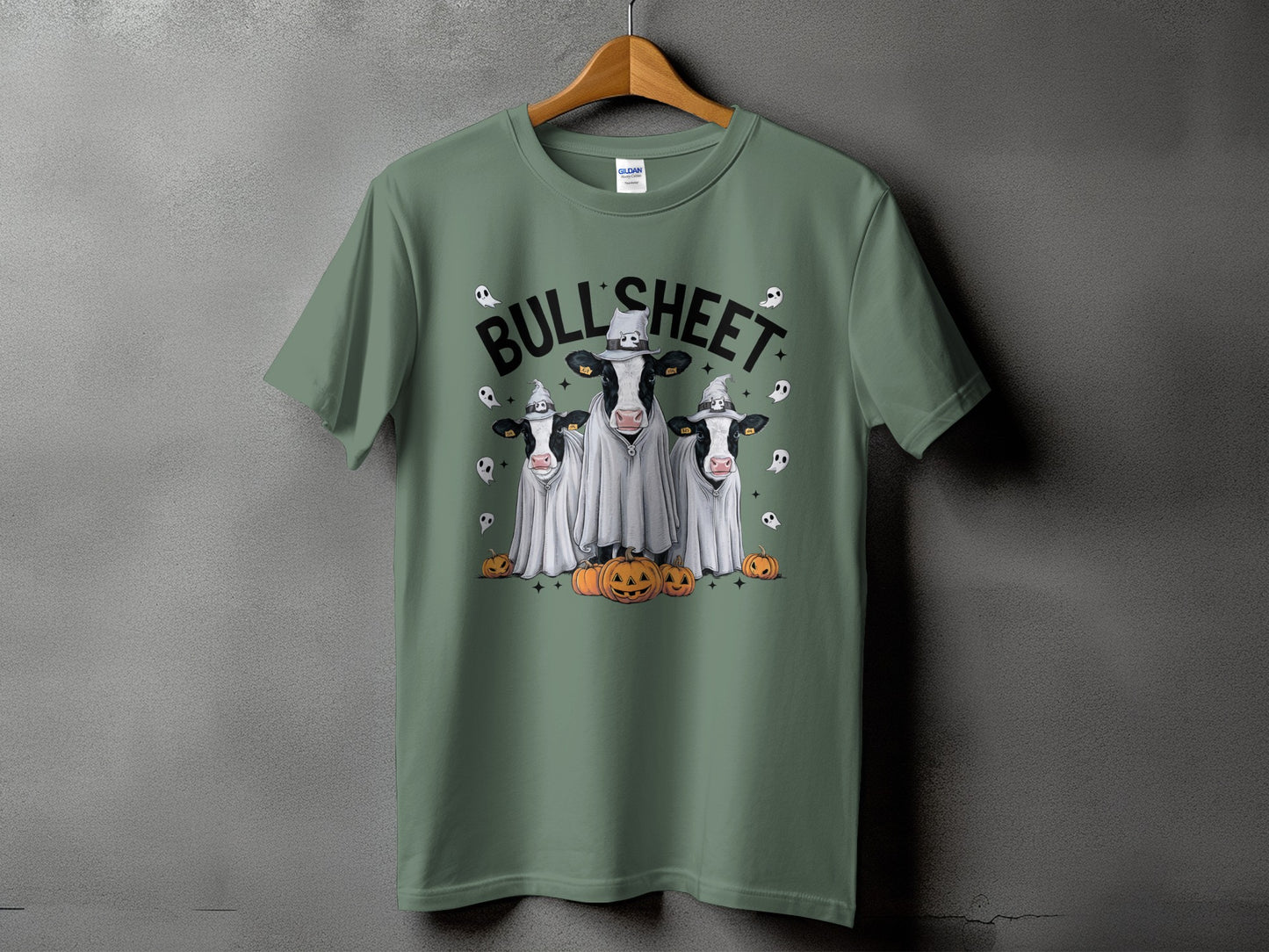 Green t-shirt with three cows dressed as ghosts and pumpkins.