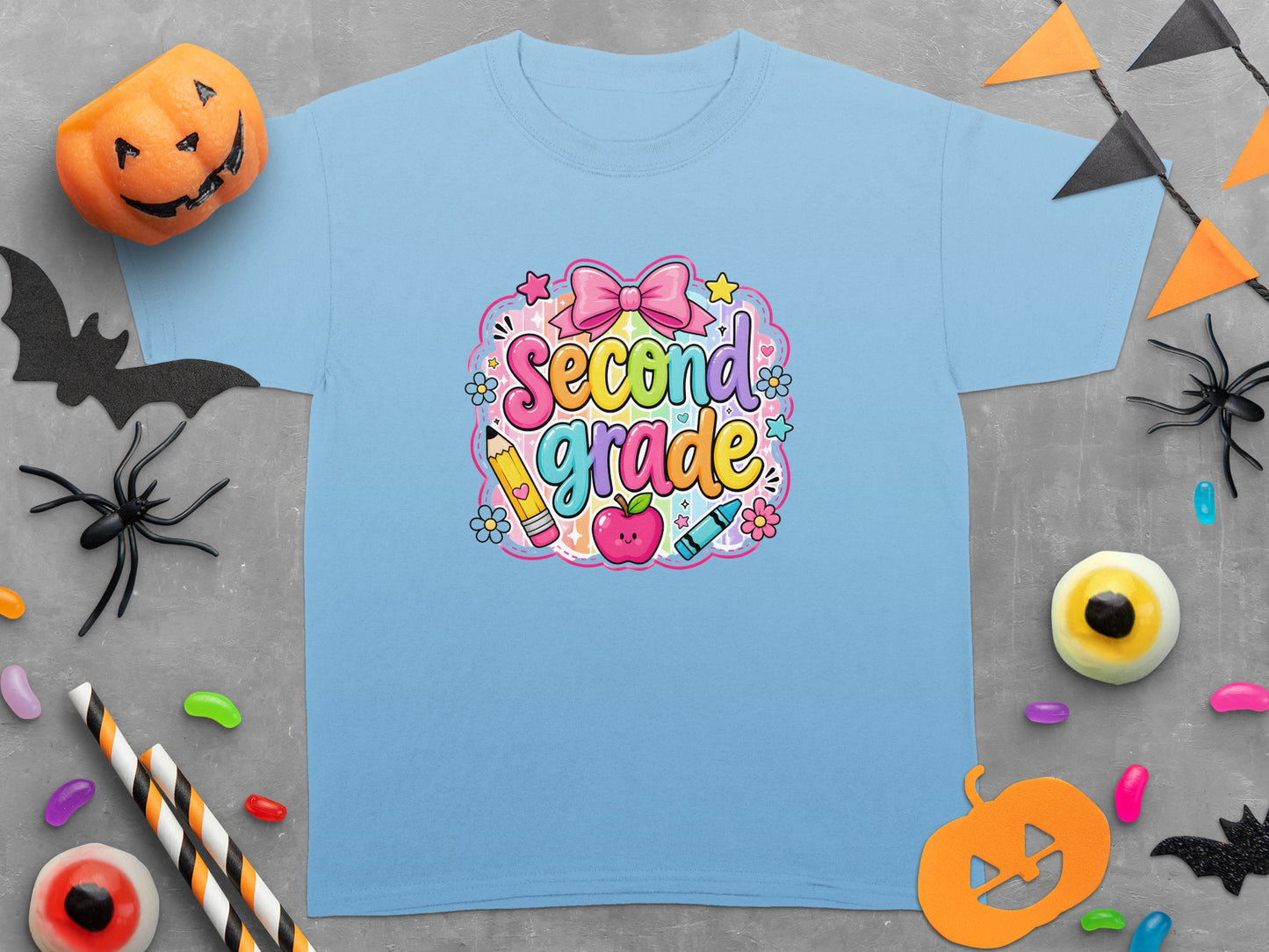 Light blue t-shirt with "Second Grade" graphic with rainbow lettering, bow, apple, pencil and crayon.
