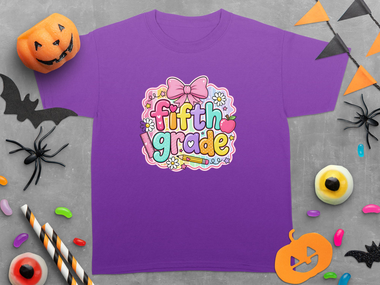 Purple t-shirt with "Fifth Grade" text graphic, surrounded by Halloween decorations.