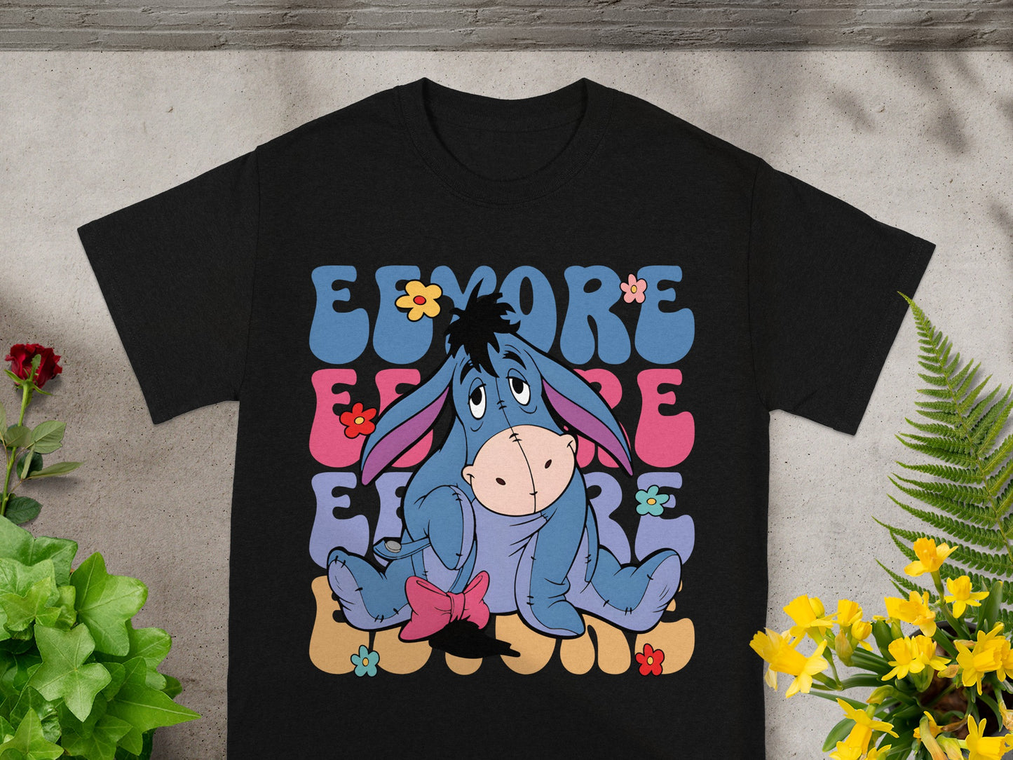 Black t-shirt with Eeyore graphic and colorful floral design.