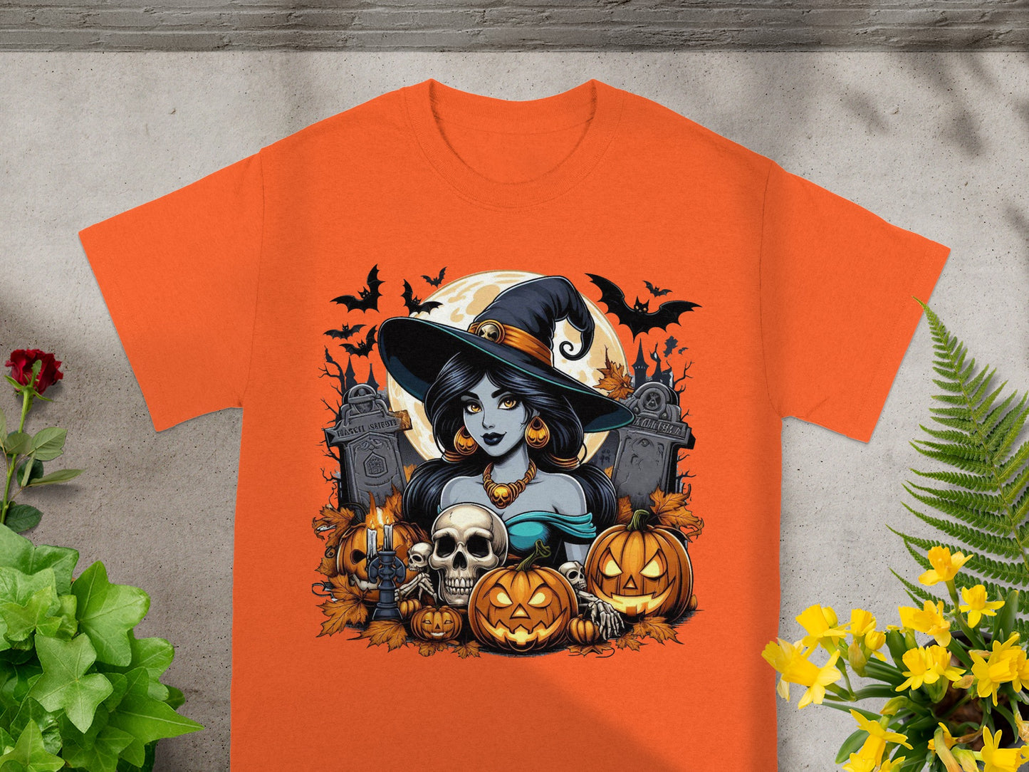 Halloween t-shirt design featuring a witch, skulls, pumpkins, bats, and gravestones.