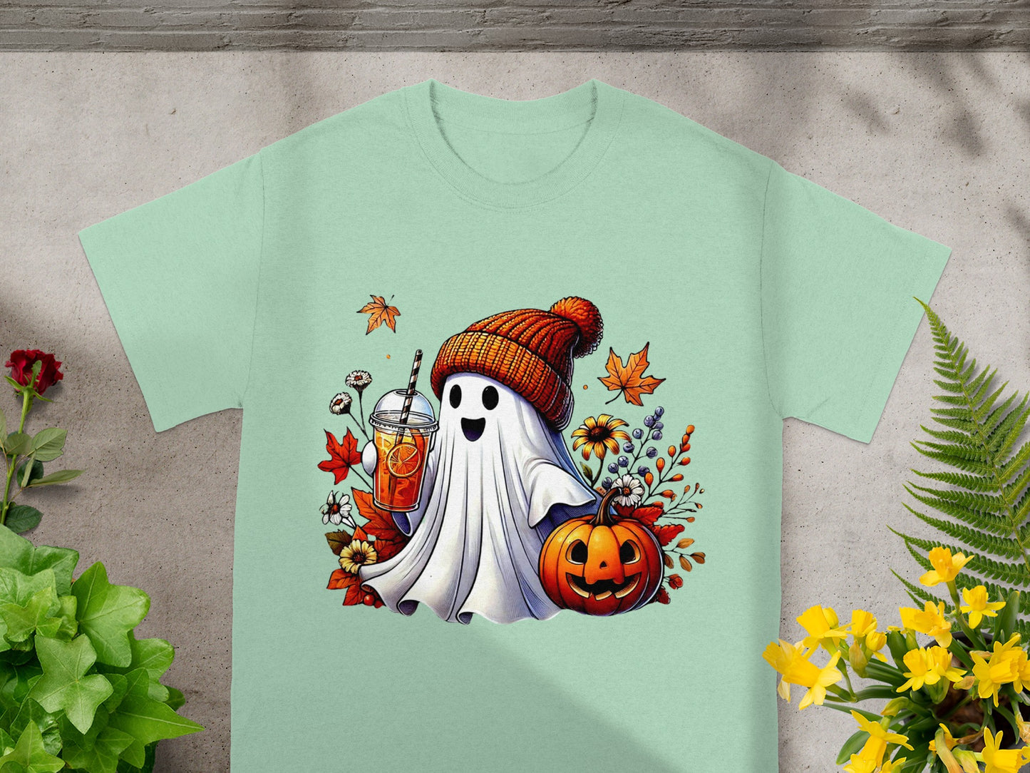 Ghost with a drink, pumpkin, and autumn leaves on a mint t-shirt.