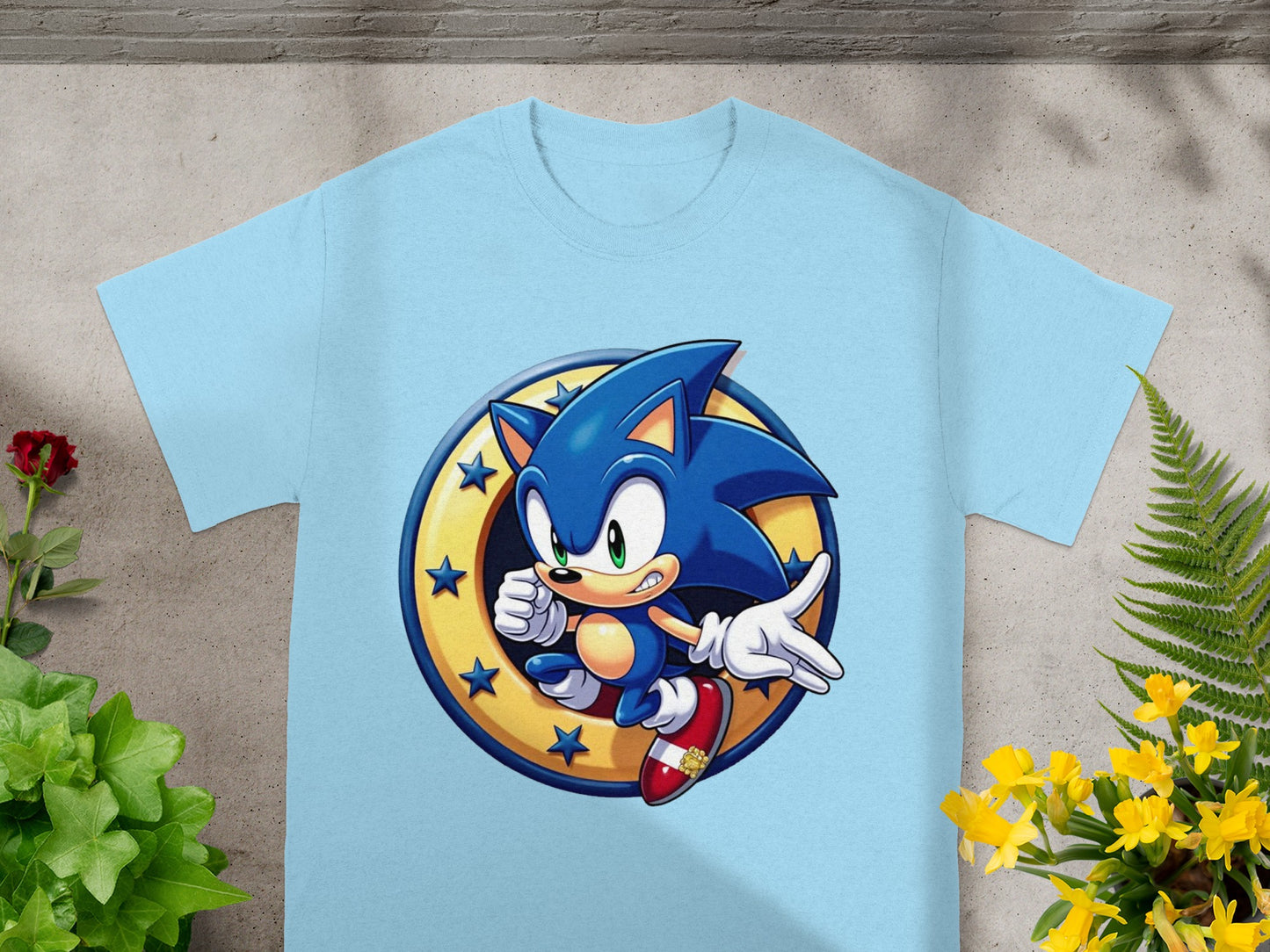 Sonic the Hedgehog in iconic pose with gold ring emblem on a light blue t-shirt.