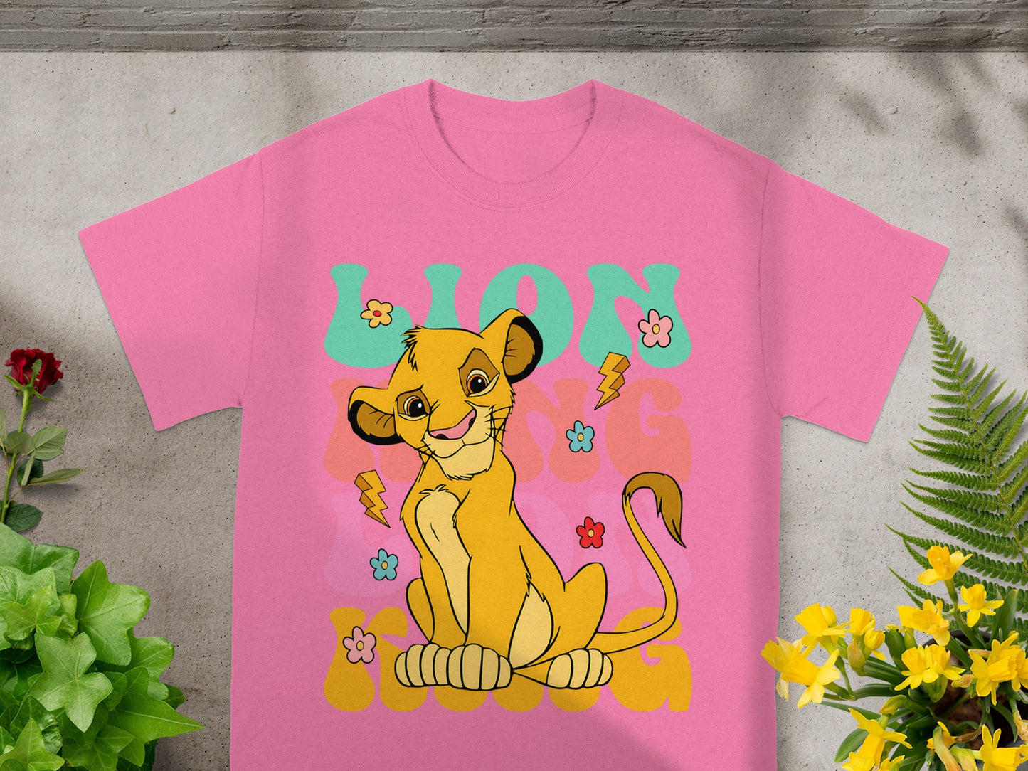 Simba from The Lion King on a pink t-shirt with flowers and lightning bolts.