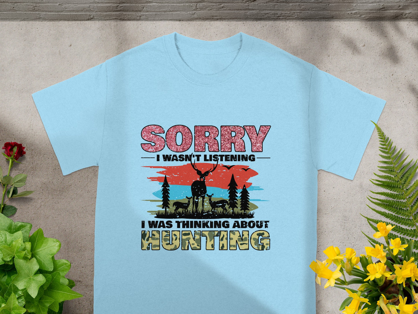 Light blue t-shirt with "Sorry, I wasn't listening. I was thinking about hunting." text and deer graphic.