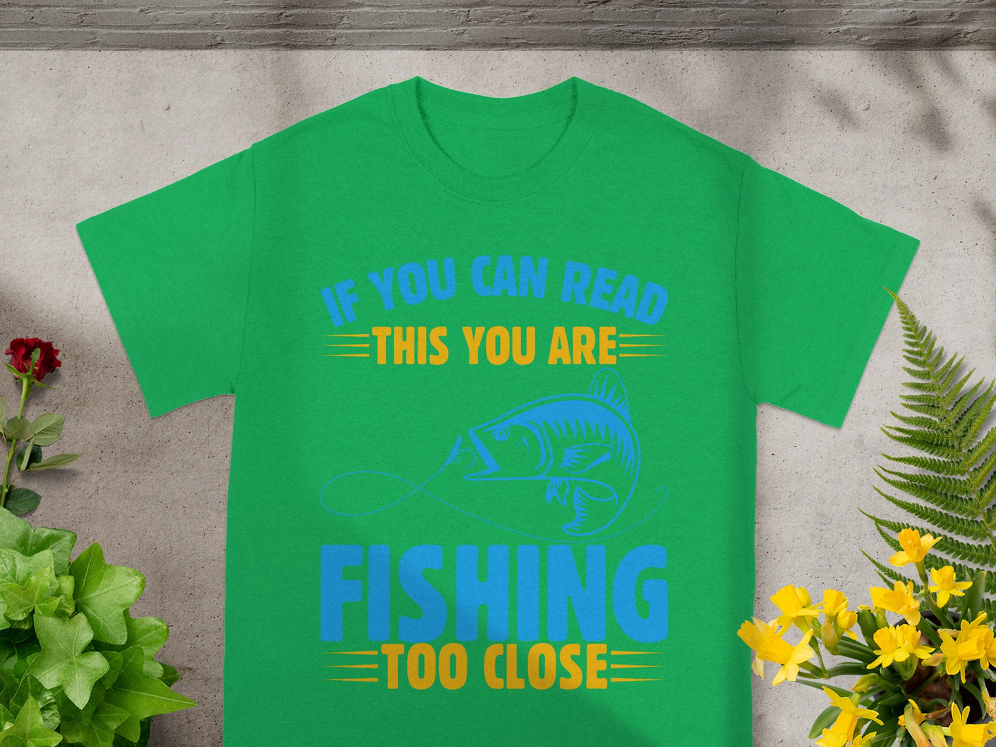 Green t-shirt with blue and yellow text and fish graphic.