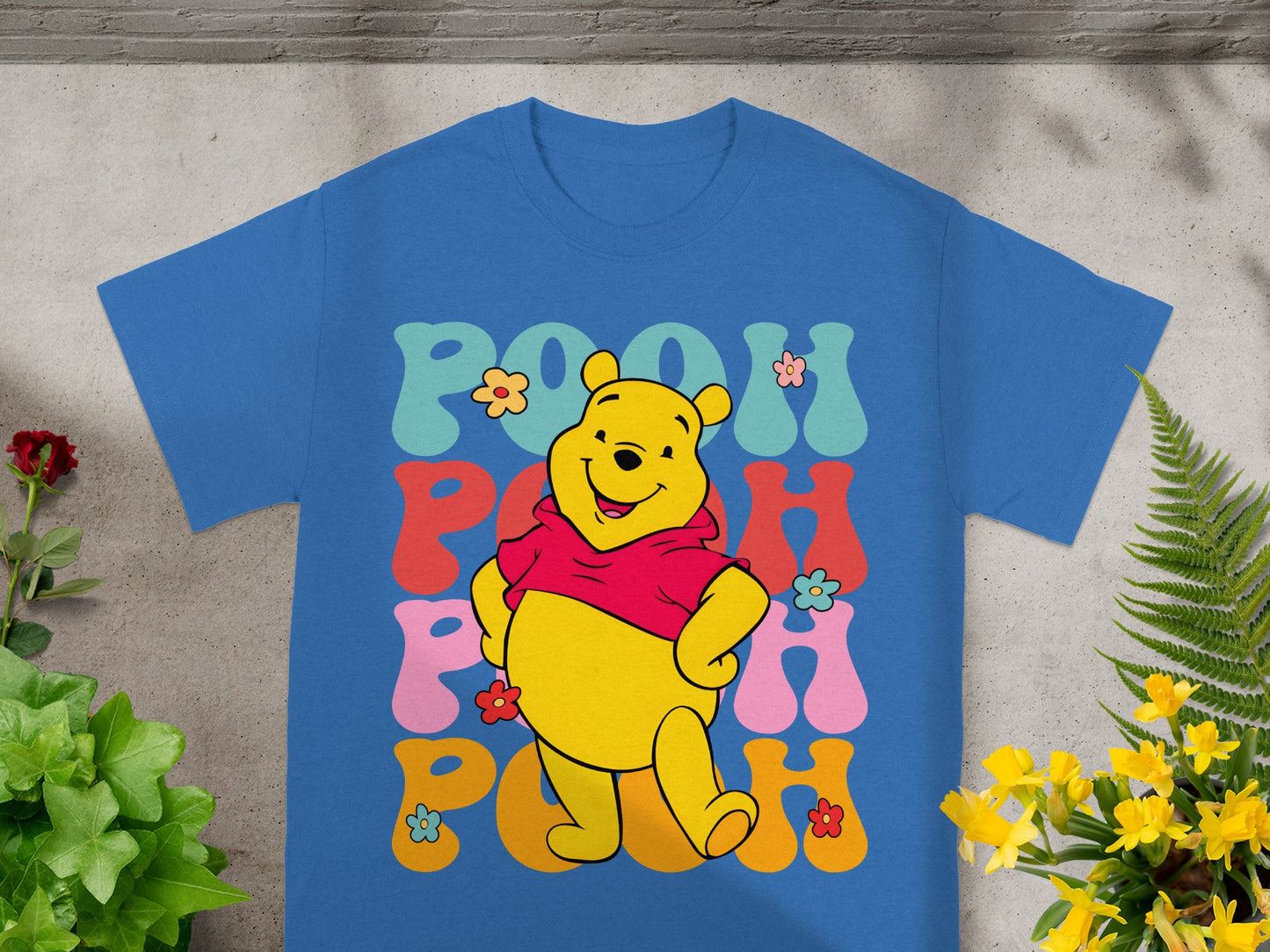 Blue t-shirt with Winnie the Pooh and "POOH" text in retro colorful font.