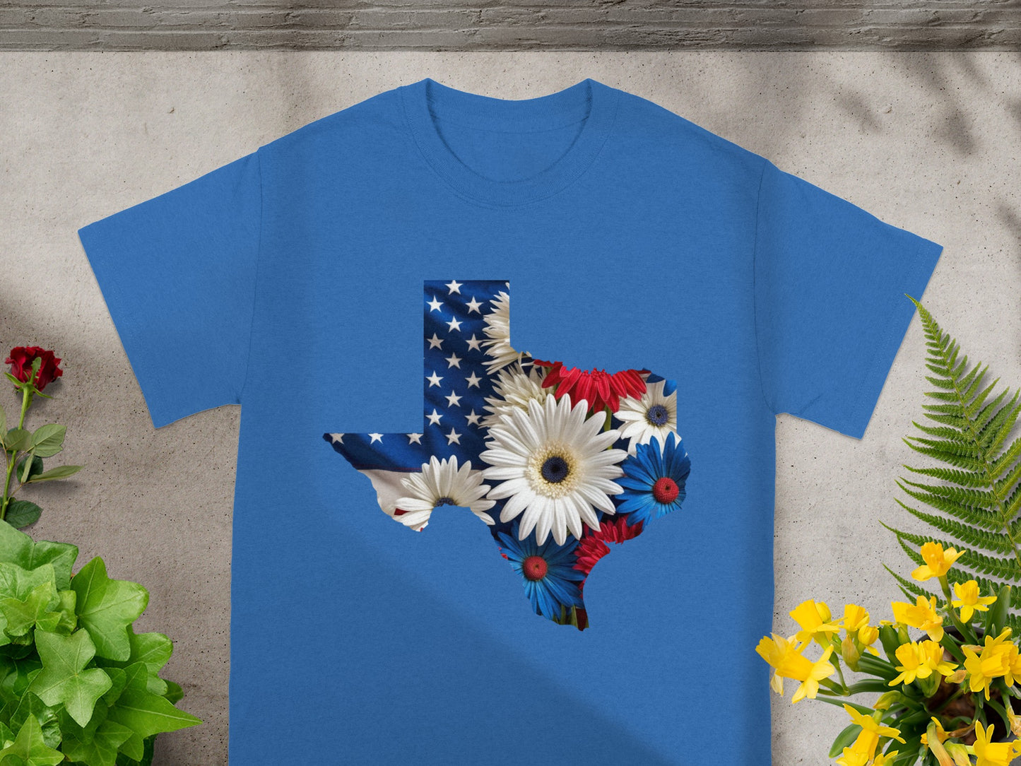 Blue t-shirt with Texas outline filled with American flag and flowers.