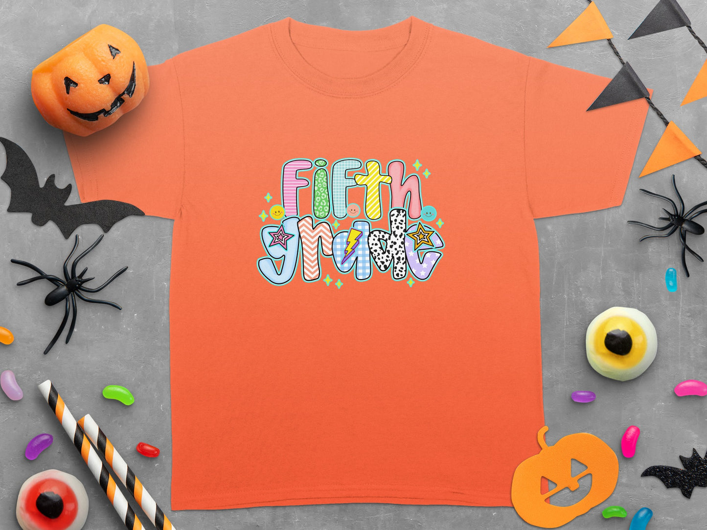 Orange t-shirt with "Fifth Grade" Halloween-themed graphic and festive decorations.